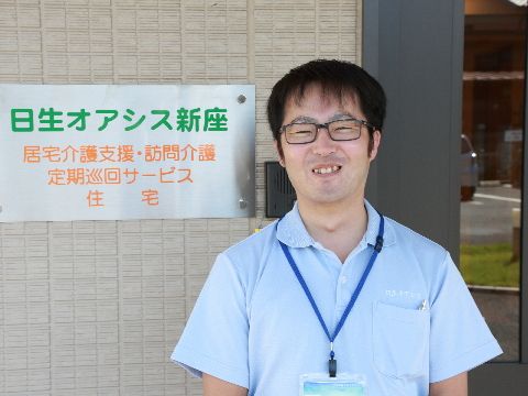 清潔感のあるブルーの服を着用した男性職員の写真。入所者様に不快感を与えない印象で、優しい雰囲気を作っている。