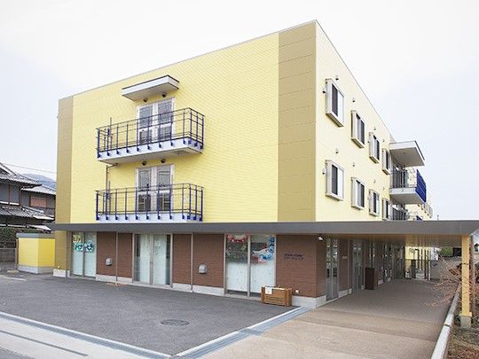 施設は3階建ての建物となっており、施設の横にはバイクなども駐車できる駐輪場が設置されている。施設前の通路には屋根が備えられている。