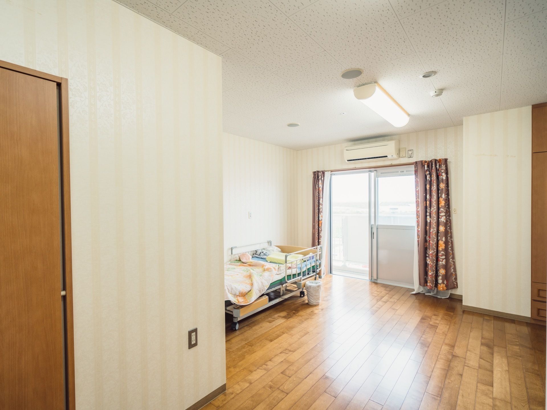 各居室には、バルコニーに出られる金属のスライドドアが設置してある。その上のスペースにエアコンが配置されている。