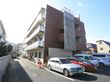 施設は４階建ての建物となっている。外に駐車場と駐輪場がある。周辺に駅や商業施設もあるが、公園など緑豊かな環境である。