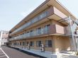 正面玄関から見て建物左端を捉えた外観。職員出入り口が設けてあり、職員駐車場がある。夜間の出入り口もある。