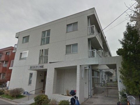 入り口前はスタッフの手入れが行き届いた植栽が植えられている。玄関ポーチの屋根に施設名が表示されている。