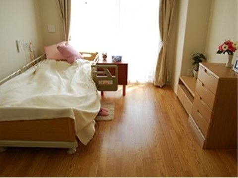 好みの高さに調整可能な電動ベッドには丈夫な補助バーを取り付けることができ、立ち上がりや軽い歩行練習などにご利用いただける。