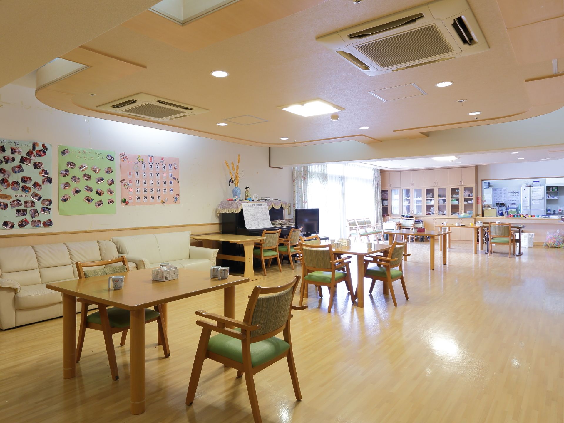 ゆったりと家具が配置された食堂兼居間。壁際に置かれたソファーとアップライトのピアノが存在感を放っている。