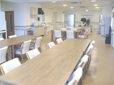 4人掛けのテーブルが並べられた食堂は、通路にも余裕があり、車椅子での移動も楽にできる。テレビや冷蔵庫も設置されている。