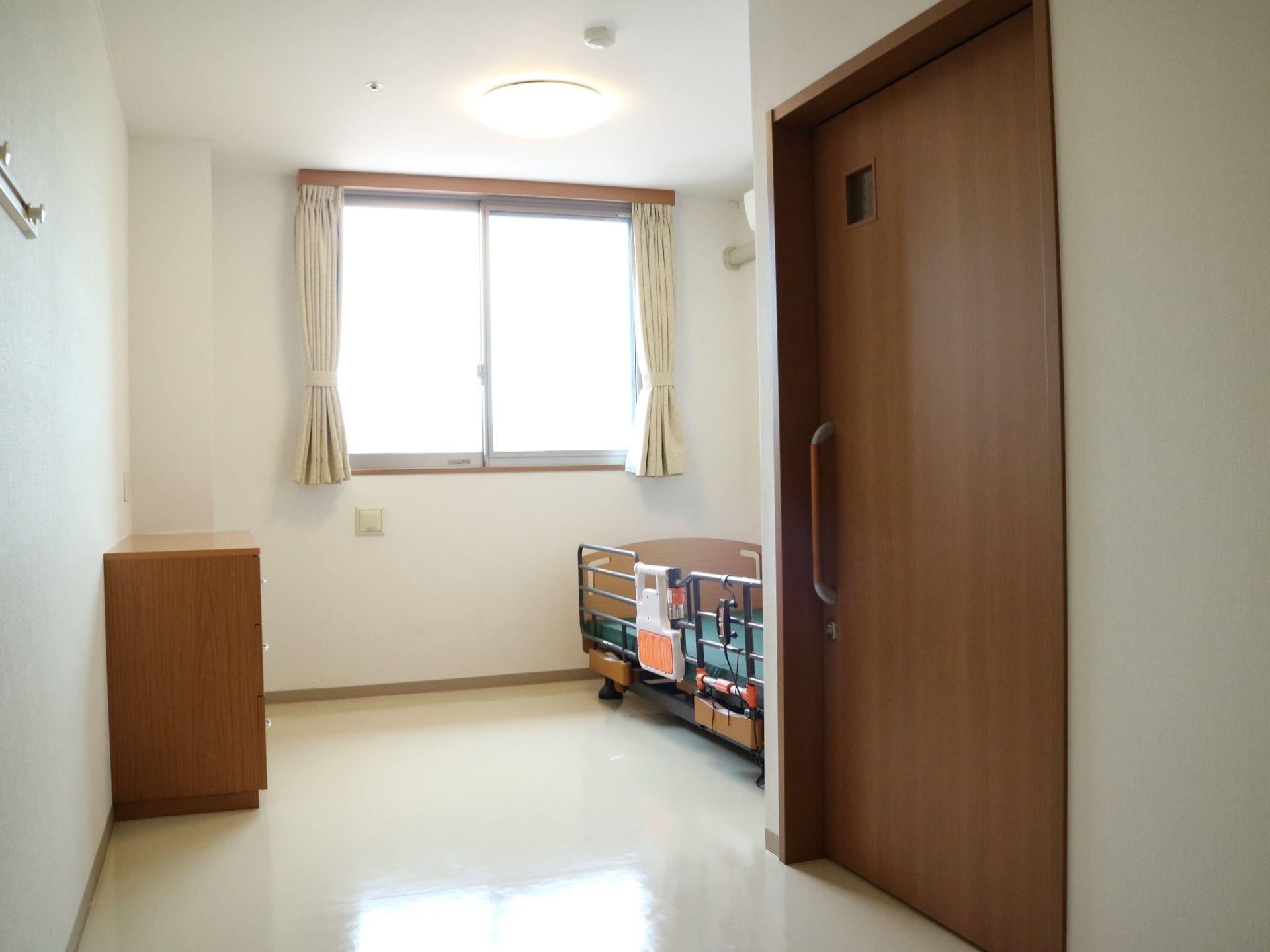 個室トイレが常設された居室である。物品などを収納できるタンスのほか、高齢者向けのベッドが設置されている。