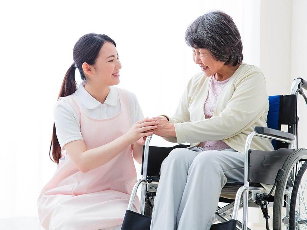 白いご飯を口元まで持って行こうとする女性の介助スタッフ