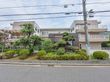 綺麗に剪定された庭木は、季節ごとに違う色が見られ、その奥の建物がこちらの施設である。季節ごとに違う姿を見せる。