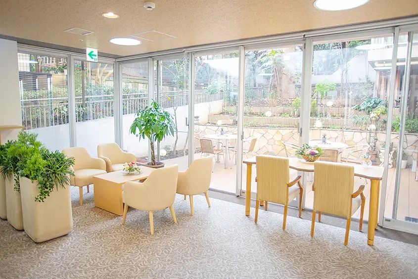 大きな窓の手前に緑のソファーとテーブルが置かれている