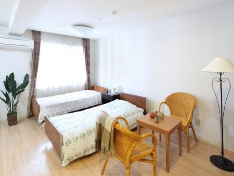 ２名様向けの居室で、広々としており、窓も大きく採光が十分である。床面はフローリングで、エアコンも完備している。