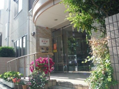 入口は自動ドアになっていて、左側に施設名が書かれている。道のりはスロープと階段があり、手すりが付いている。
