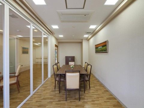 白壁のコンパクトで落ち着いた雰囲気の相談室。照明と空調が完備されており、部屋の中央にはテーブルセットが設けられている。