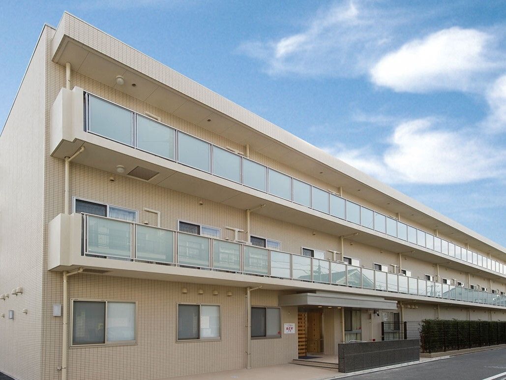 アイボリー色の外壁で、３階建ての建物である。施設の前に駐車場があり、出入りしやすい。入口前は段差がない。