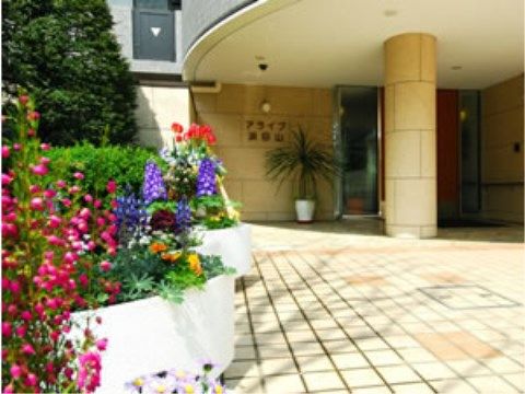「アライブ浜田山」の玄関ポーチ。入居者様の心を鷲づかみにする、色とりどりの花々がお出迎え。