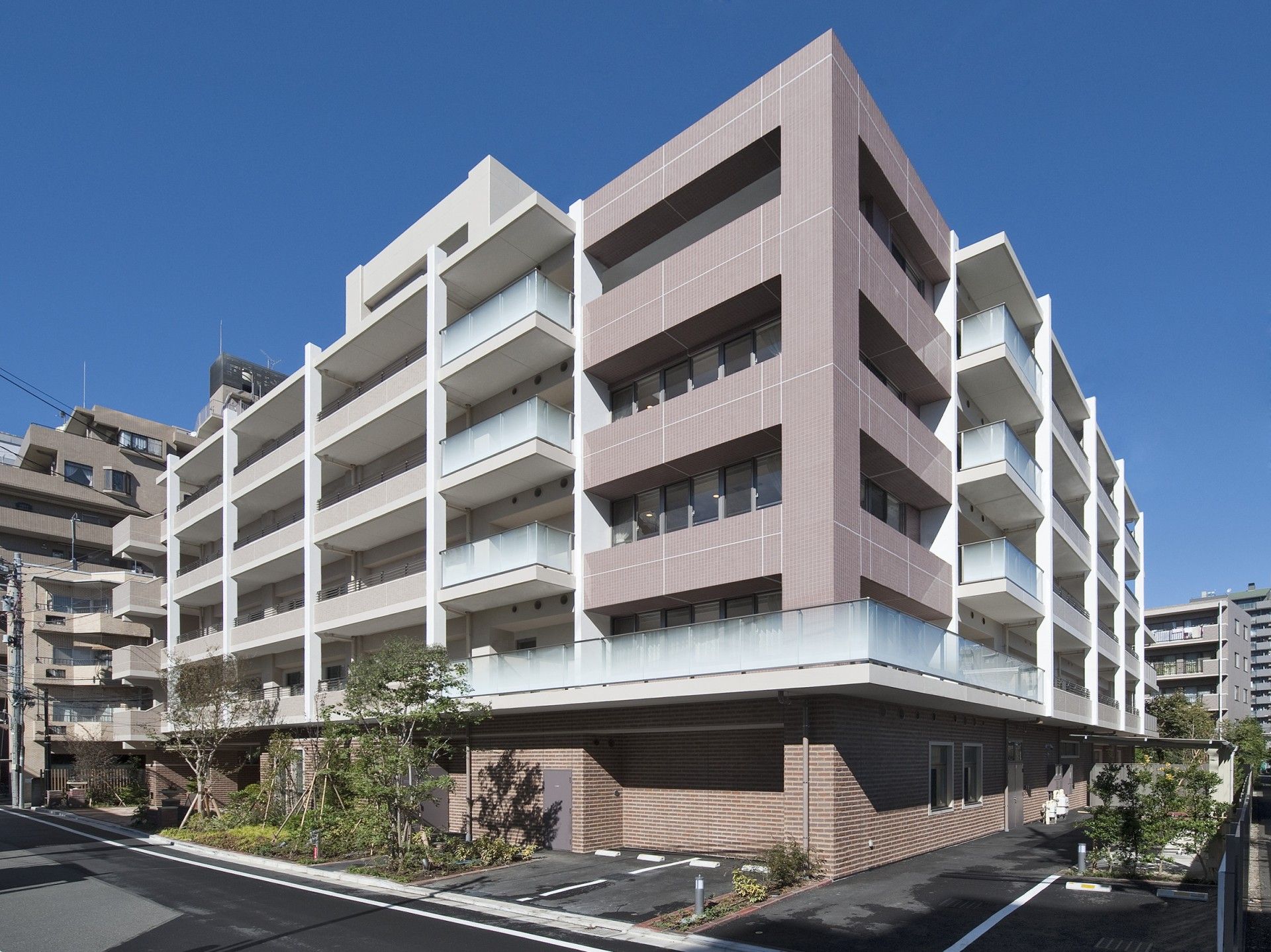 白色のタイル調の外観の５階建ての建物である。１階部分は、茶系のレンガ調で、一番上部には、屋上スペースがある。