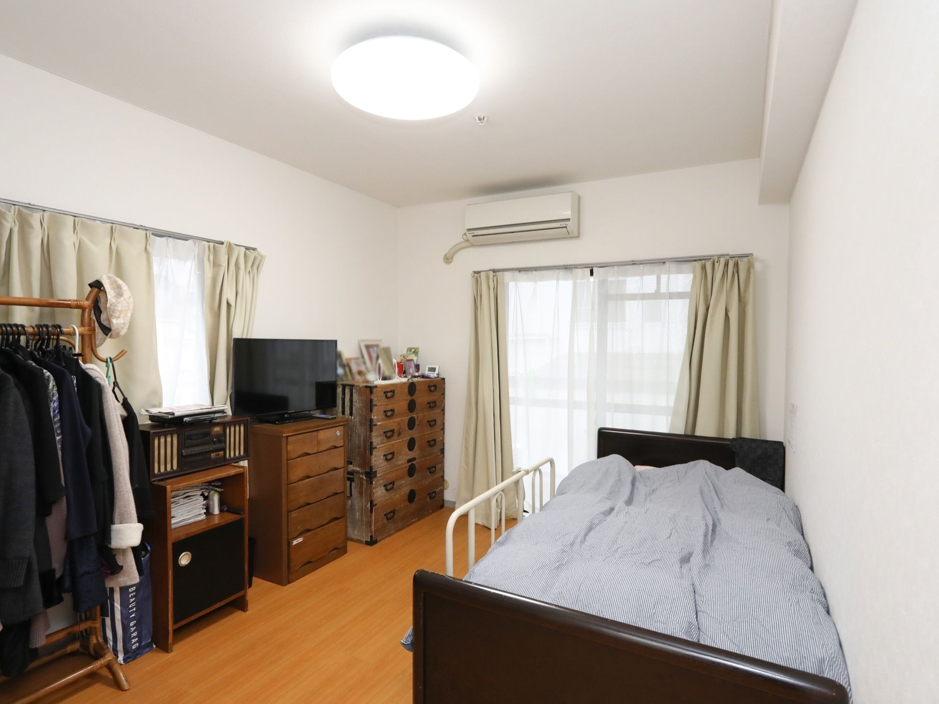 居室は広々としており、２面に窓が備え付けられている。ベッドやタンスなどの調度品が数多く設置されている。