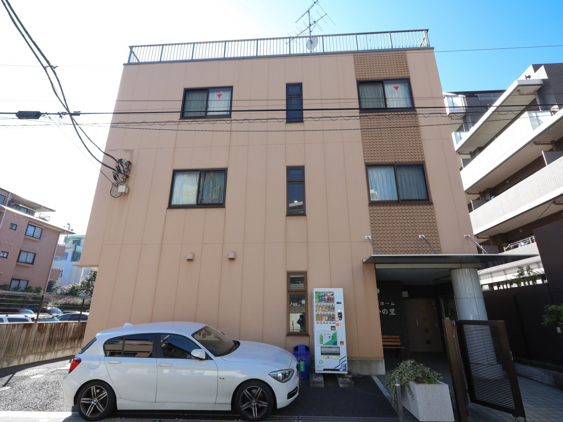 外観は住宅街になじむベージュのシンプルな建物である。奥行きのある敷地の北側が道路になっており、小さな門を抜けると玄関となっている。