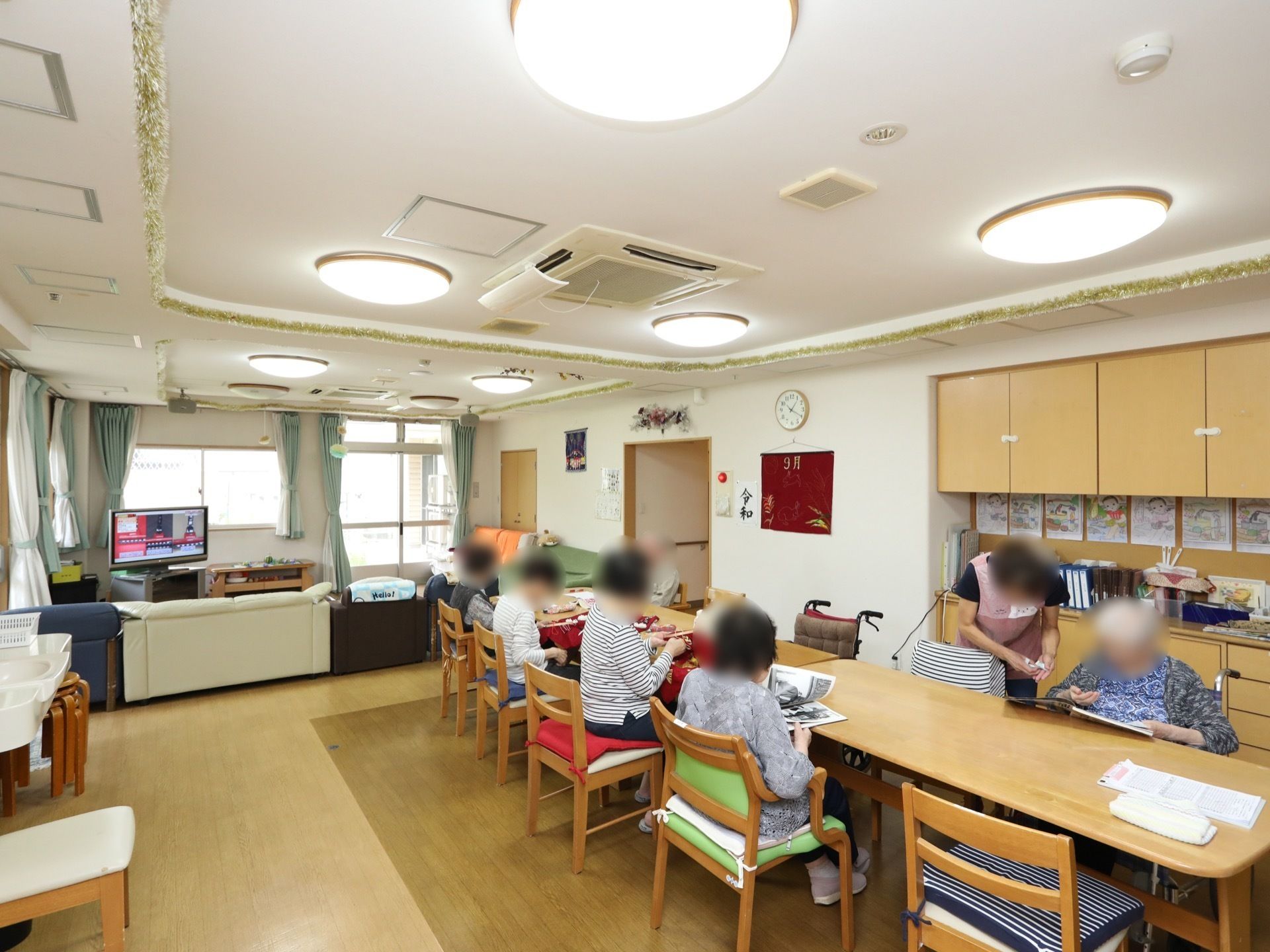 施設内には広い共有スペースがあり、リビングとダイニングが設けられている。テーブルや椅子もたくさん並べられている。
