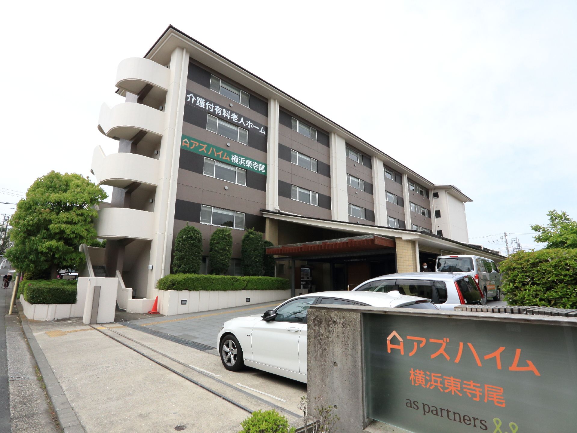 施設は5階建てになっている。車を何台か止められるスペースもある。4階と5階部分の壁には施設名が書かれている。