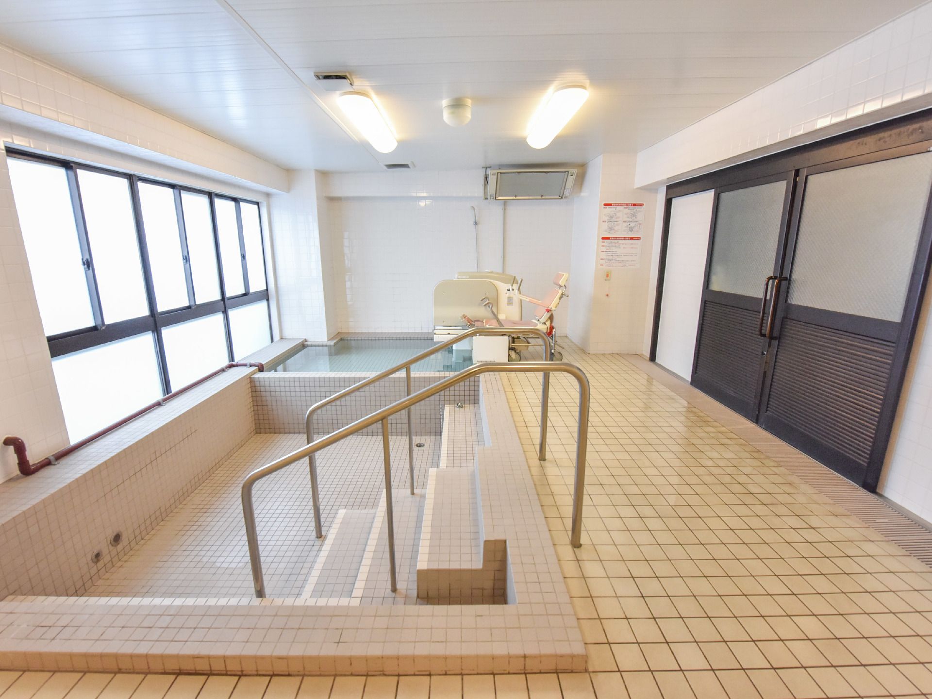お風呂の浴槽は介護用リフトがある方とない方の2か所に分かれている。リフトがない方の浴槽は手すりが付いていて、浴槽内が階段になっている。