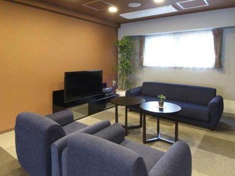 濃青色のゆったりとしたソファとローテーブルが置かれた休憩スペース