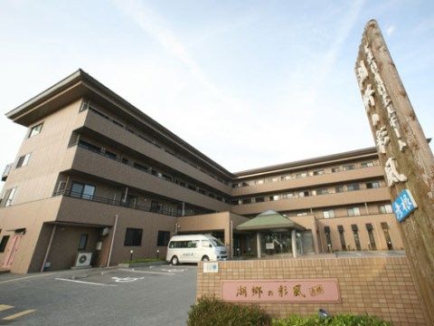 「湖郷の彩風 彦根」の外観。すぐ近くに琵琶湖が見える、こげ茶色の４階建てのタイル張りの外観。