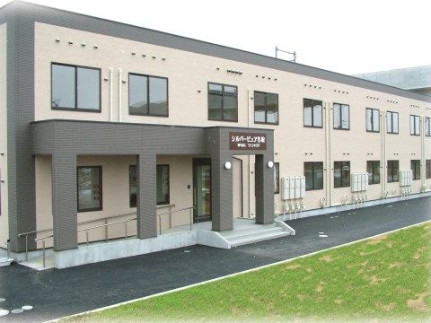 「シルバーピュア三沢」の外観。自然豊か溢れる土地に、木造2階建ての風の音だけが聞こえる居心地の良い施設。