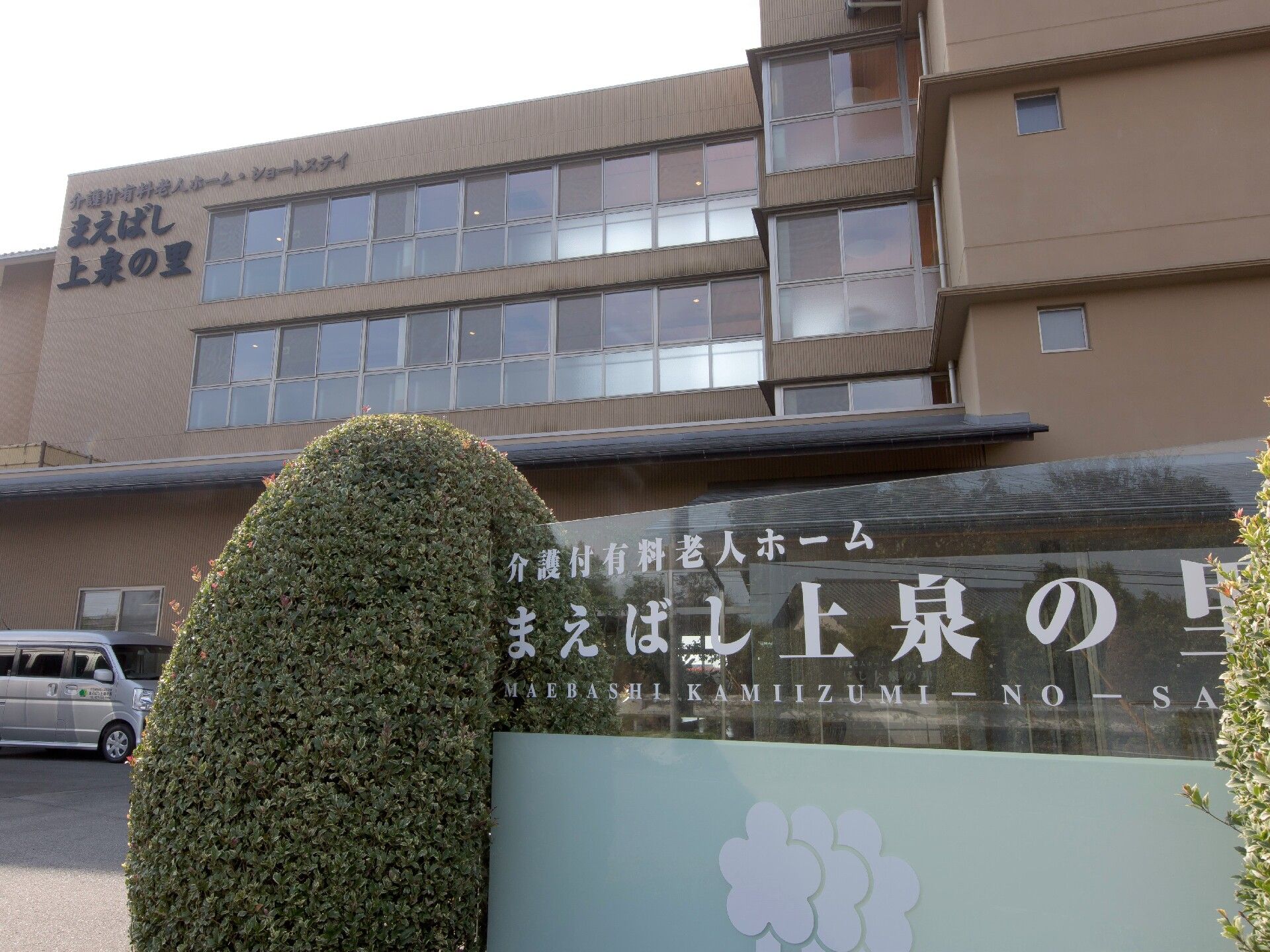 「まえばし上泉の里」の外観。暖色を使った明るい外壁の施設外観です。マンションのように大きな、しっかりとした建物です。