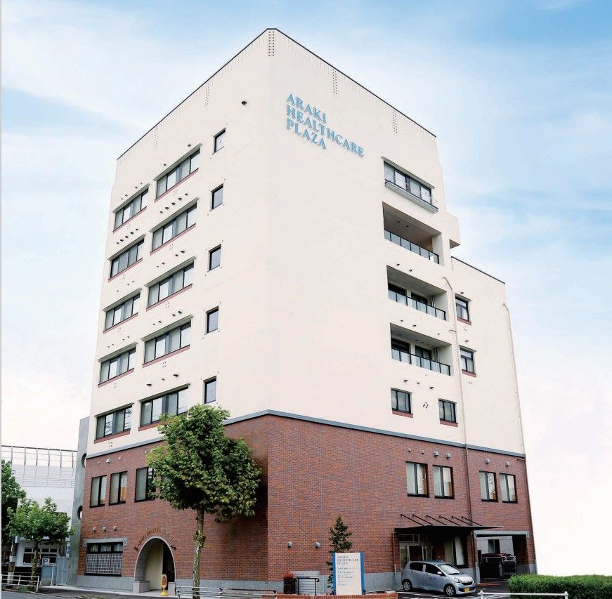 なにかを指さして笑顔で話している車いすの女性とそれを押している介護スタッフの様子