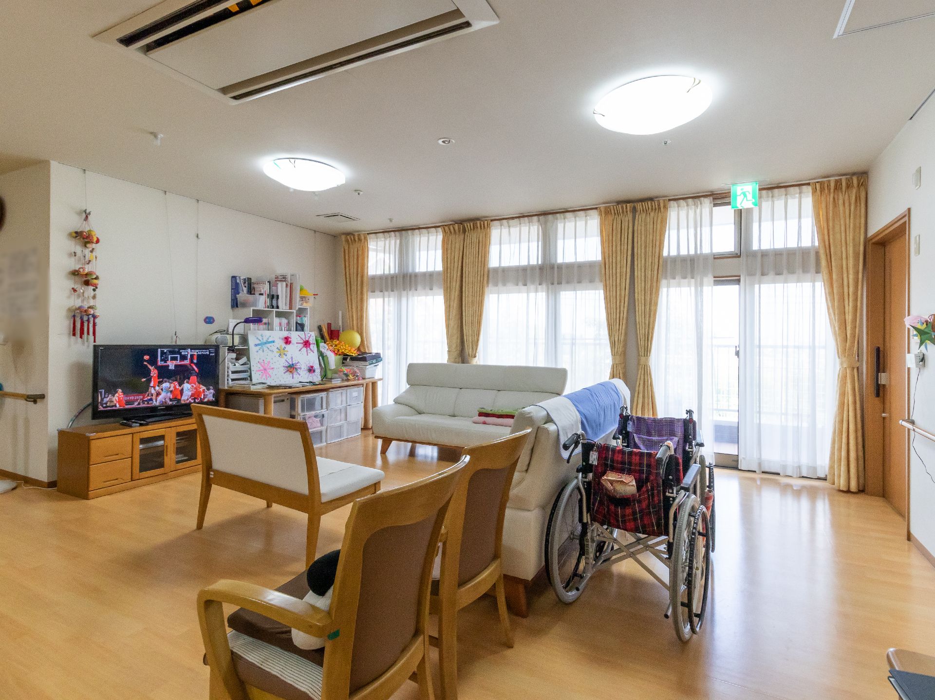部屋の一面がすべてガラス戸で、陽光がたっぷりと入ってくるリビング