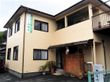 一軒家のような大きめの建物の写真。入り口付近に植物が置かれている様子