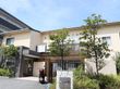 建物の周りの植え込みを活用して、緑の多いホームである。高い樹木は２階まで届き、目隠しとしても機能している。