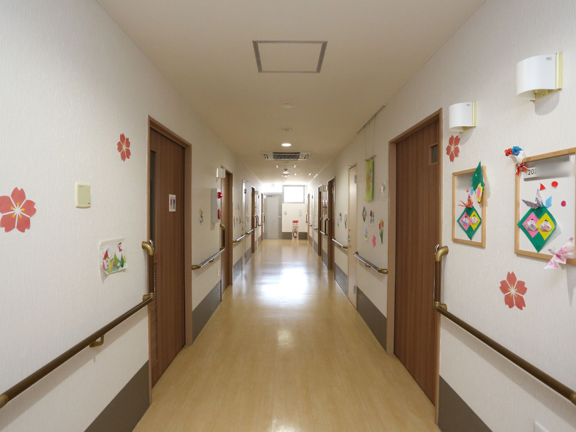 居室と同じ並びにトイレがある。壁にはお雛様や梅の飾りがたくさんあり、明るく季節感を感じさせる空間になっている。