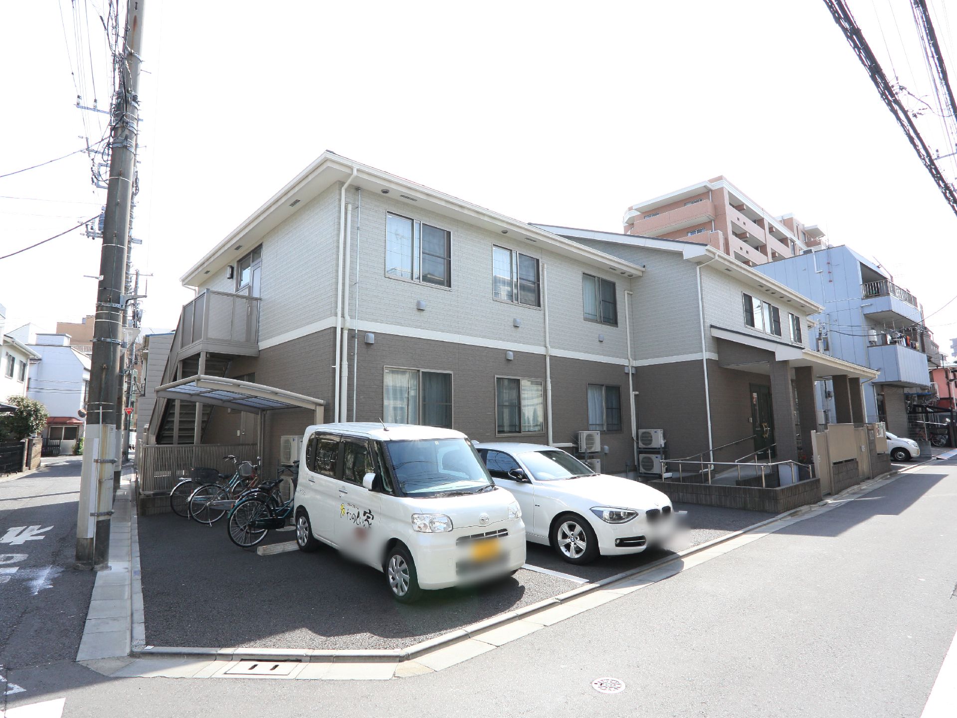2階建ての賃貸アパートのような施設。建物のすぐ前に駐車場と駐輪場があり、使い勝手が良い。スロープも設置されている。
