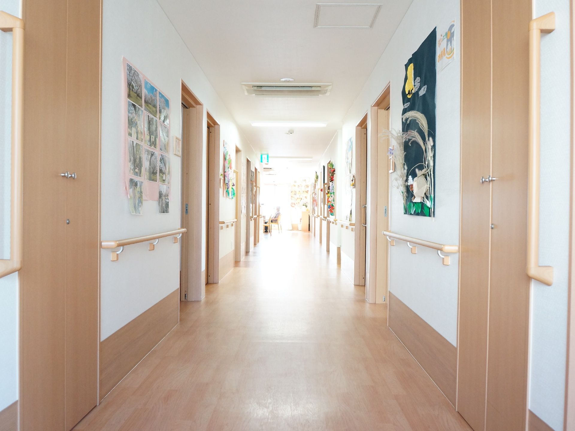廊下の両側に手すりが取り付けられている。壁には季節ごとの利用者の制作作品が飾られてたり、利用者の写真が掲示されている。