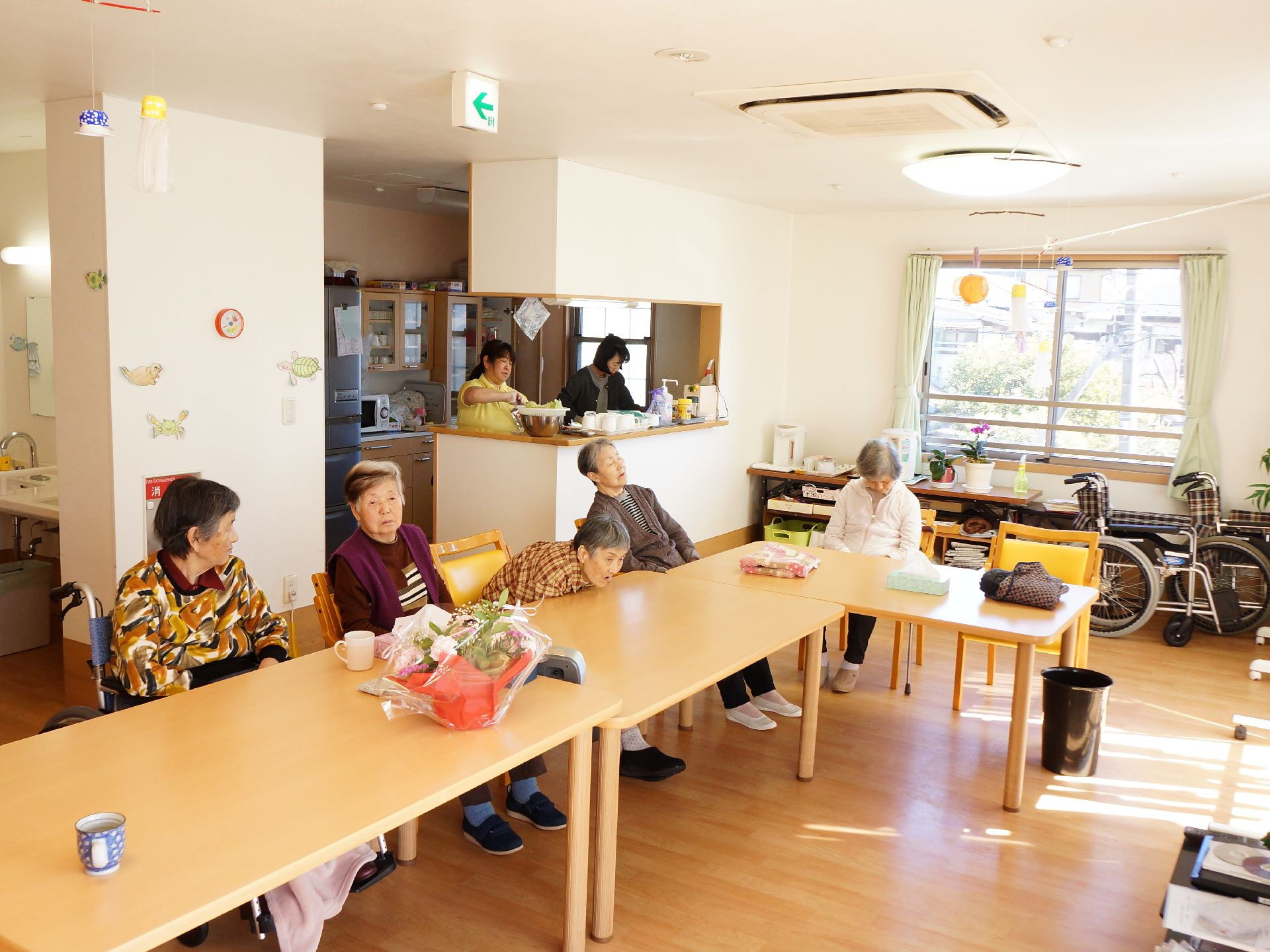食堂内は、自然な木目調の床で、窓から自然な光が差し込んでくる。広いスペースにテーブルと椅子が並べられている。