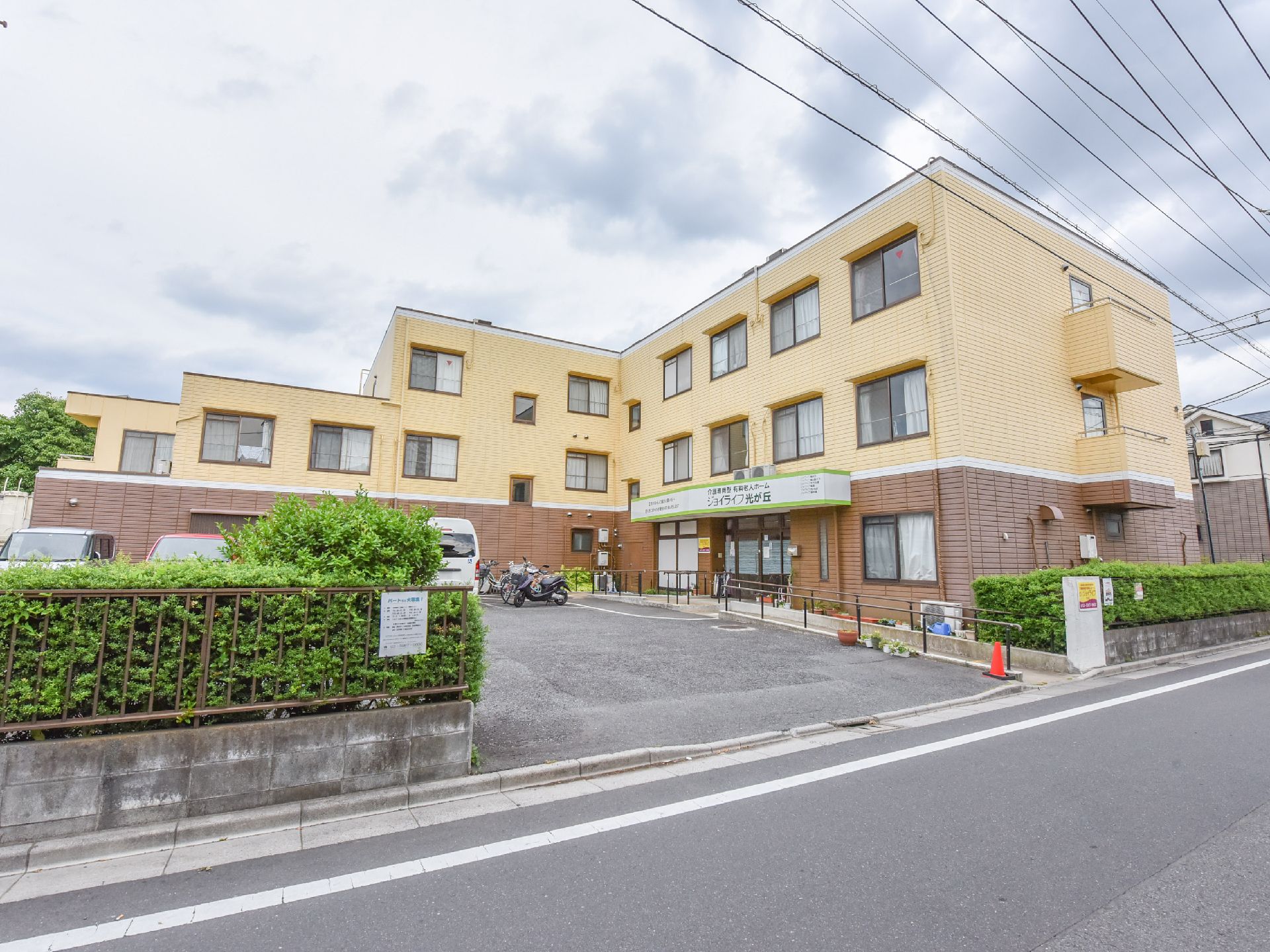 施設は道路に面している。植え込みに囲まれた入り口を入ると車の駐車スペースと施設建物が見えるようになっている。