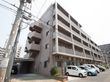 茶色を基調とした施設建物は、道路に面した場所に建てられている。建物前に、駐車スペースが設けられている。