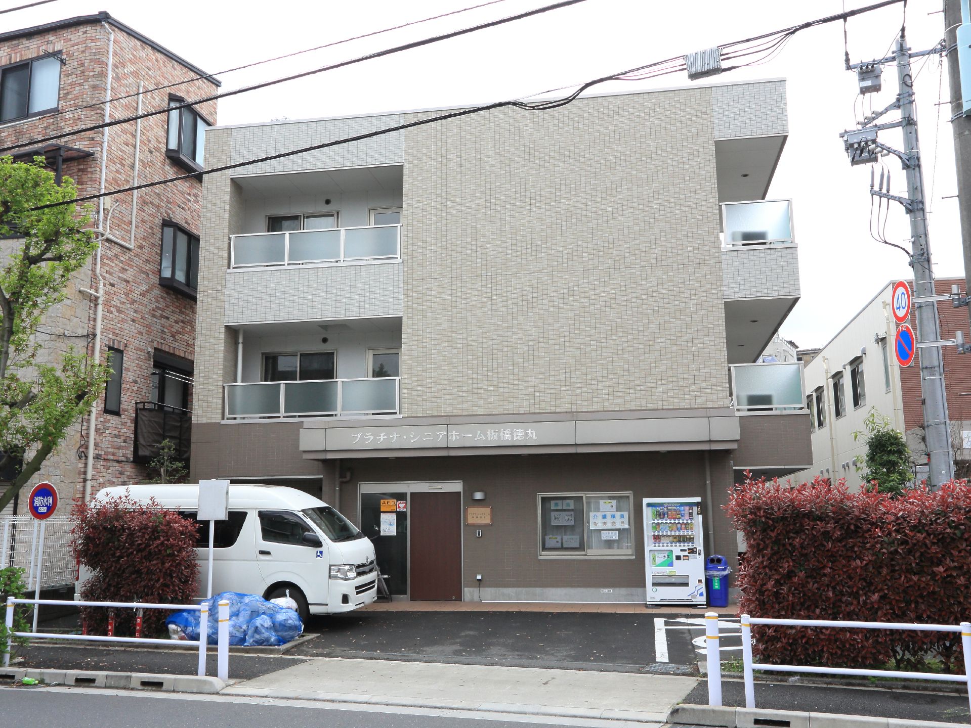 3階建てのマンション型建物で、通りに面しているので、分かりやすい場所にある。送迎車や自動販売機などがある。