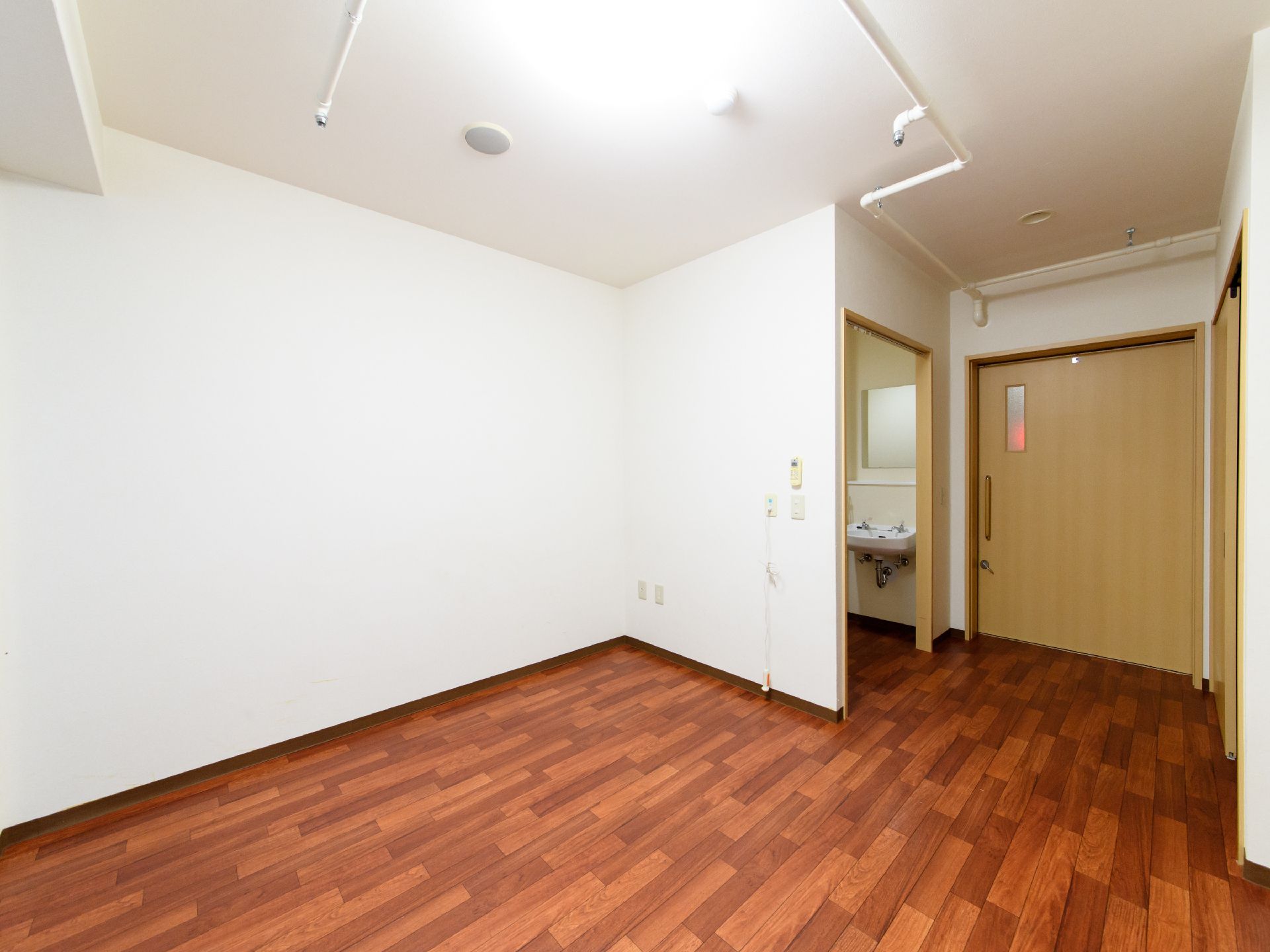 居室の天井と壁は、白色で統一されている。床はこげ茶色で、入口の扉などは木目調である。入口は横開きで、鍵が付いている。