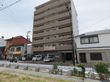 住宅街の一角にある施設で、全体的に外観が茶色である。玄関前に駐車場がある。プランターが置いてあるほか、木々も植えてある。