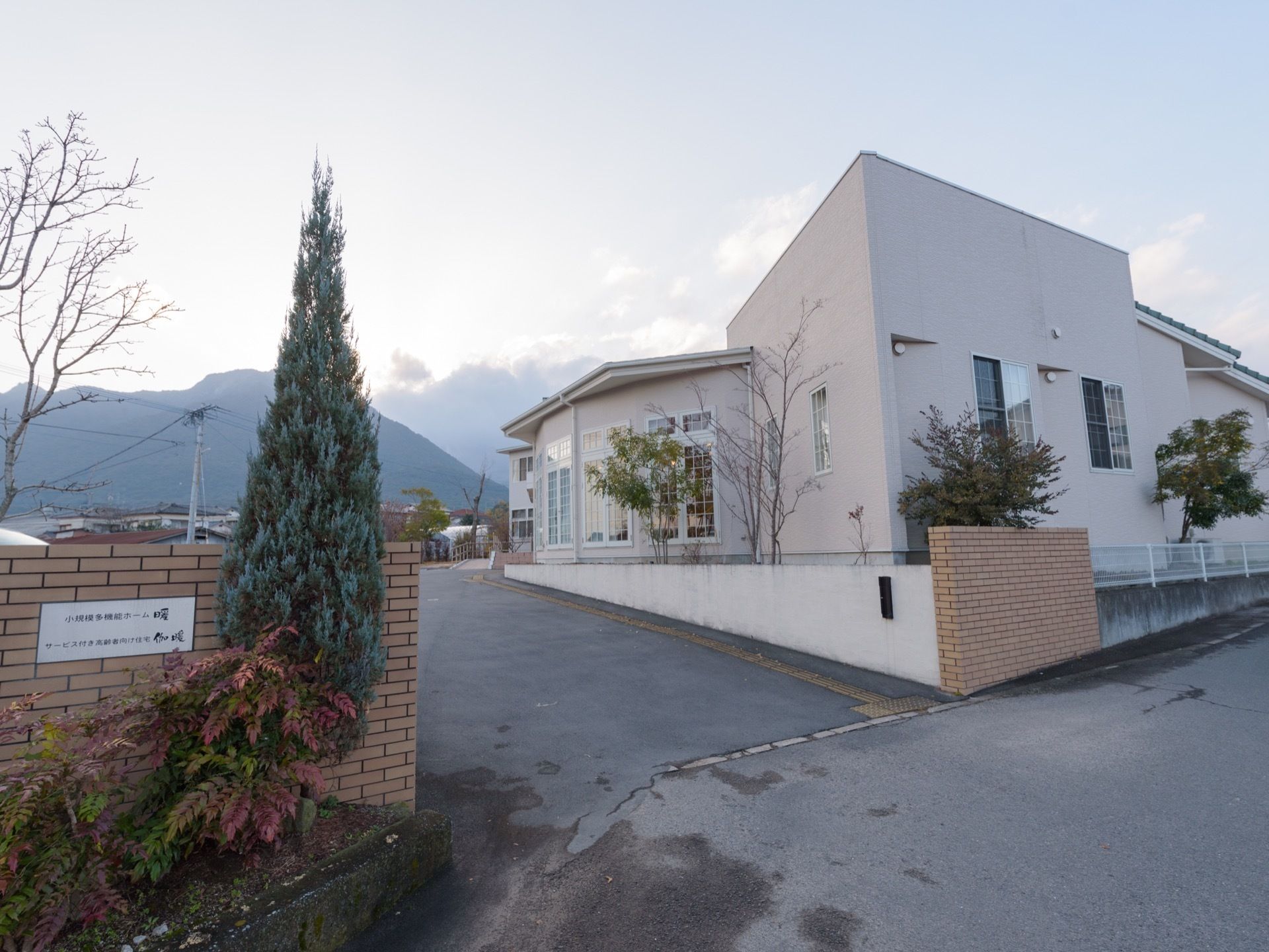 1階建ての洋風の建物で、門は広く車がスムーズに入ることができる。施設には窓がたくさん付いている。周りには植木がある。
