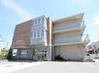 3階建ての鉄筋コンクリート製の建物で、施設の前には駐車スペースが設けられている。周囲には住宅が広がっている。