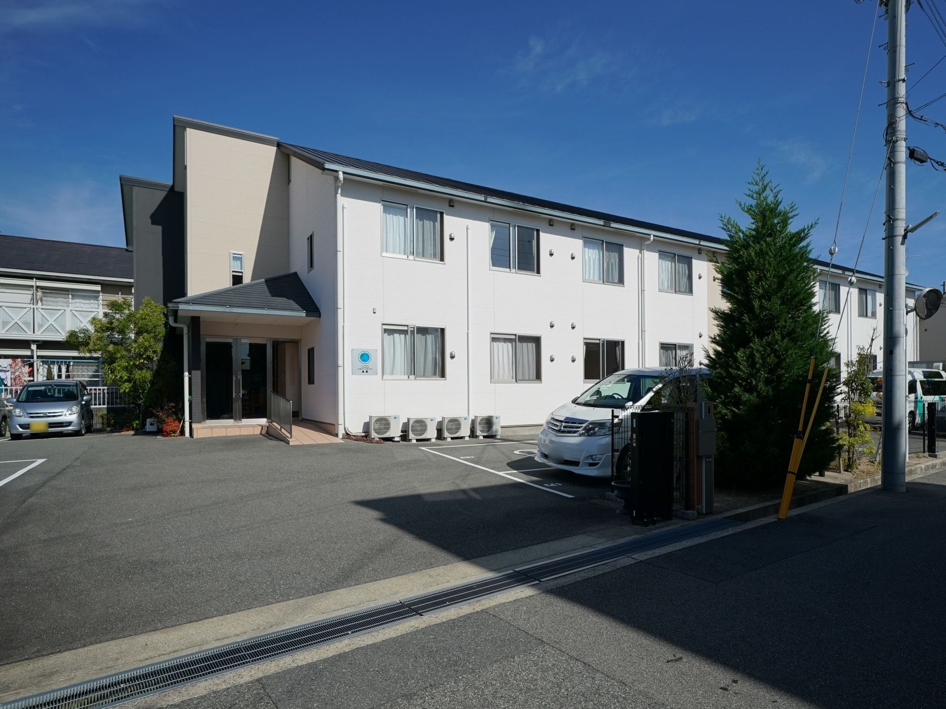 施設は白い壁の２階建ての建物である。敷地内に木々が植えられており、自然に親しみながら過ごすことができる。