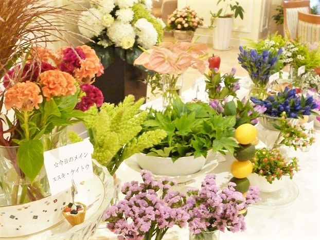 さまざまなスタイルの花器に生けられている、色鮮やかな花々や植物