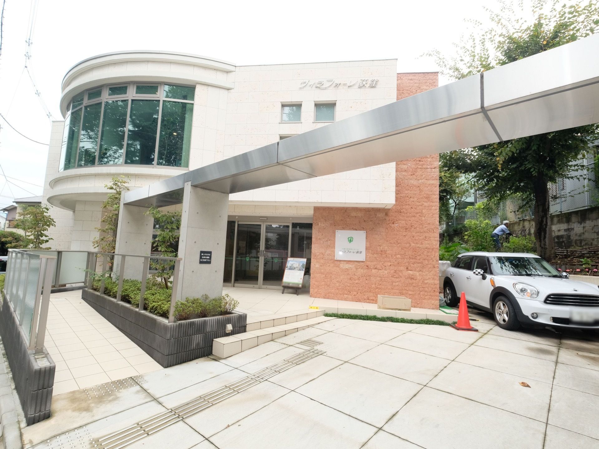 ２階建ての白壁の建物がこちらの施設となっている。ガラス窓が大きく、施設名も大きく書かれている。清潔感のある、綺麗な印象を受ける。