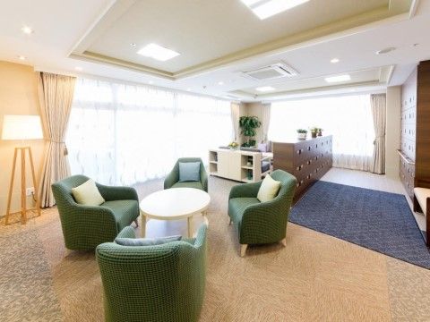 緑色の椅子が４脚円形に配置され、その真中にテーブルが置かれている。近くにはスタンドライトが設けられている。