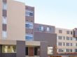 外壁はベージュと濃いブラウンのツートーン。４階建ての建物は少し変わった形が特徴的で、モダンな佇まいである。