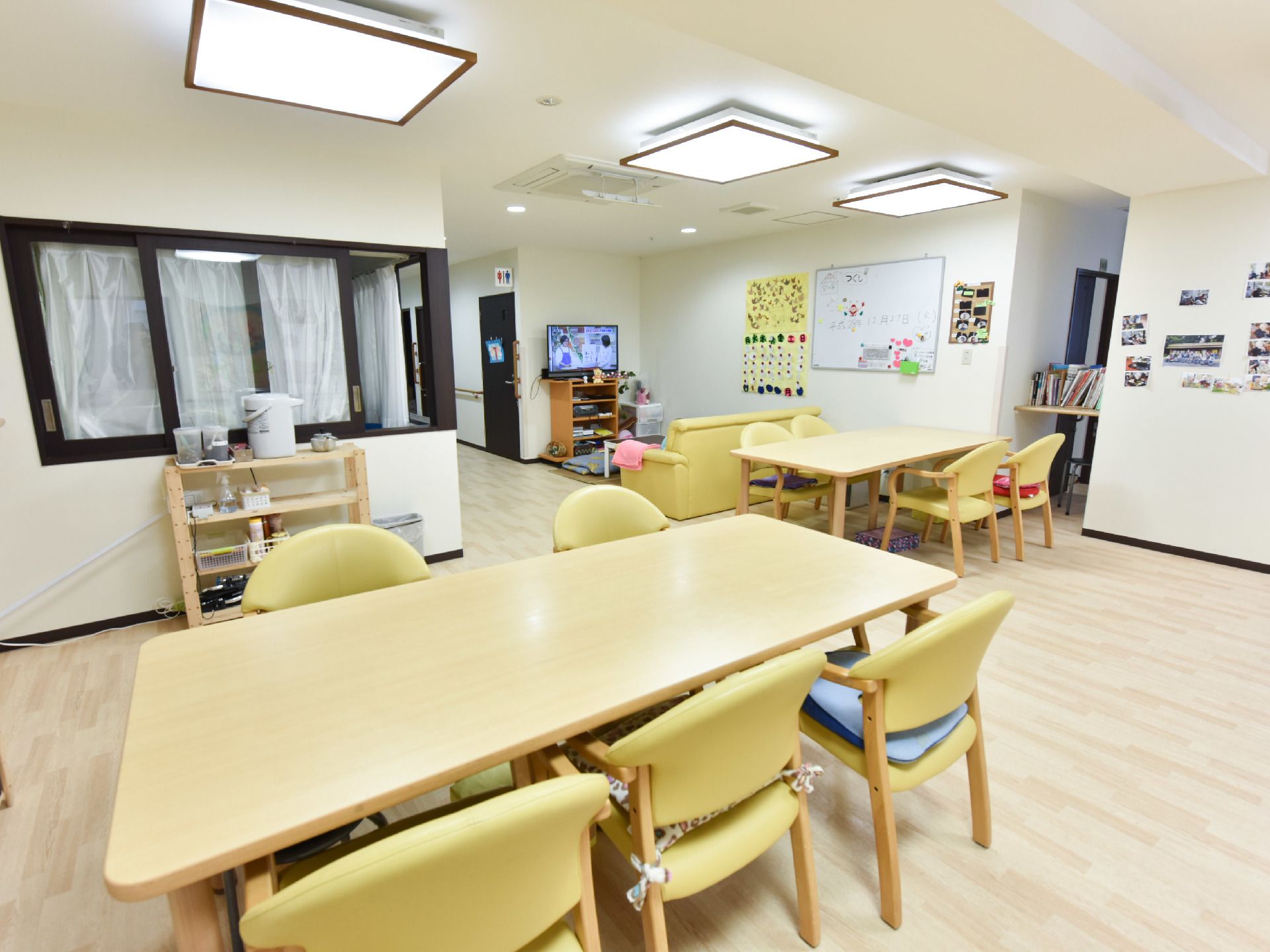 共用スペースには2か所机が置いてあり、それぞれ4脚、5脚の黄色い椅子が設置されている。廊下から続いている開放感のある空間となっている。