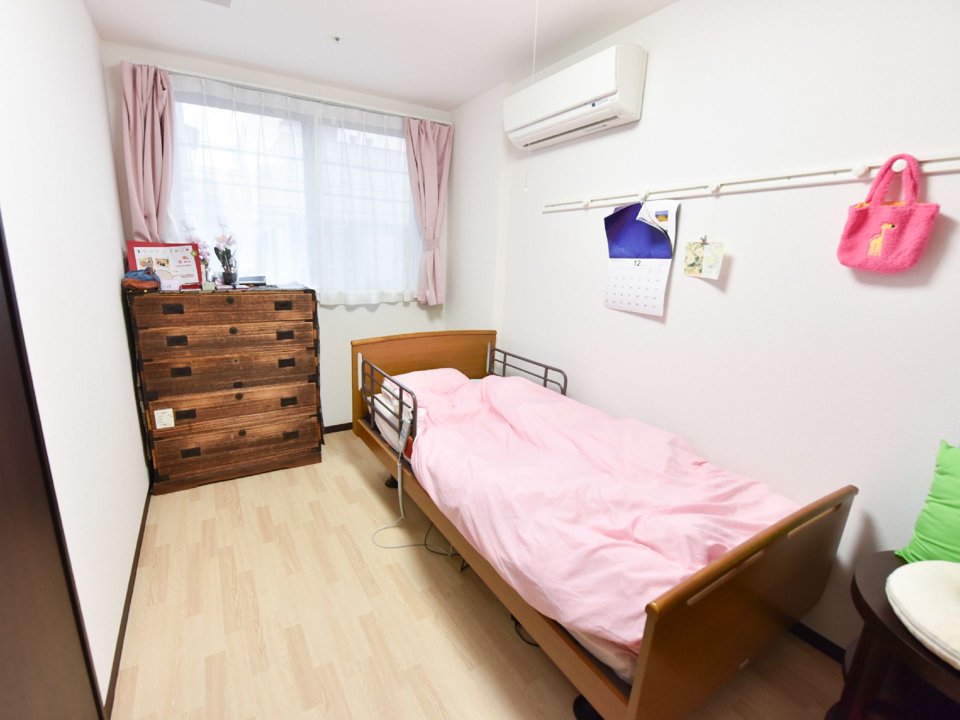 ある入居者の居室。部屋にはベッド、タンス、エアコンも取り付けられている。窓が大きいので、外の様子を見ることができる。